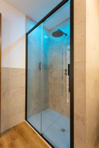 a glass shower in a bathroom with blue lighting at Ca'Bastian-Guest House in Moruzzo +47 photos