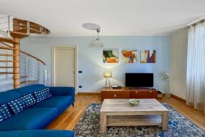 a living room with a blue couch and a coffee table at La Piazza Menaggio in Menaggio