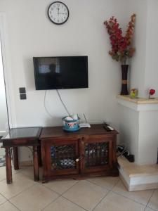 a living room with a tv on a wall with a table at SOFI APARTMENT in Ofrínion