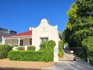 a white house with a red roof at Boschhuis Apartments - Stellenbosch in Stellenbosch