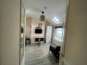 a living room with a table and chairs and a refrigerator at Charming 1Bed Flat In Dublin Sleeps 2 in Dublin +4 photos