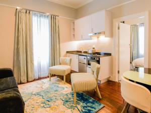 a kitchen and living room with a table and chairs at Boschhuis Apartments - Stellenbosch in Stellenbosch