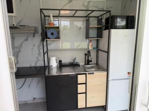 a small kitchen with a sink and a refrigerator at Teemeistri Camp in Tõrva