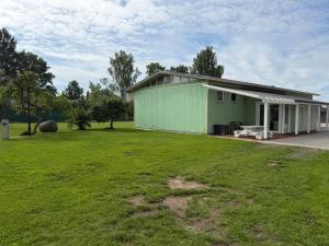 a green building with a grass field in front of it at Teemeistri Camp in Tõrva