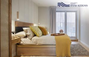 a bedroom with a bed with yellow pillows and a window at ALTZOAN Apartamentos Turísticos y aparcamiento gratuito in Zarautz