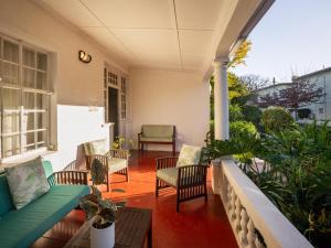 a patio with a couch and chairs on a porch at Boschhuis Apartments - Stellenbosch in Stellenbosch +9 photos