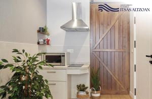 a door leading into a kitchen with a microwave at ALTZOAN Apartamentos Turísticos y aparcamiento gratuito in Zarautz