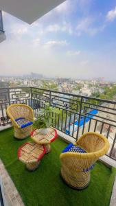 three chairs and a table on top of a balcony at Skycabinomaxe in Greater Noida +2 photos