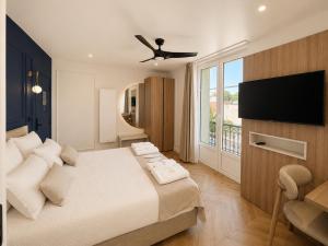 a bedroom with a bed and a flat screen tv at The Originals Residence, Les Sources Callou, Vichy in Vichy