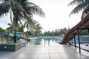 a swimming pool with a slide and palm trees at Padmabati Park in Balasore