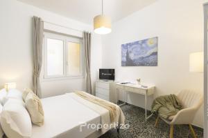 a bedroom with a bed and a desk and a window at Central Cagliari by Propertize in Cagliari