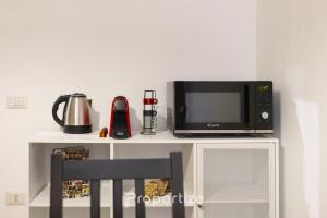 a microwave oven sitting on top of a white shelf at Central Cagliari by Propertize in Cagliari