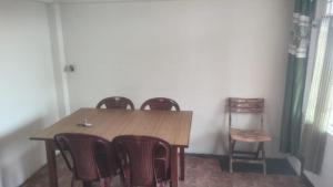 a dining room table with four chairs and a wooden table at Salena Homestay in Cherrapunji