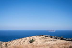 an island on top of a hill near the ocean at Ayelma - Kythnos Villa in Kithnos +15 photos
