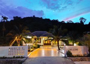 a home with palm trees and a driveway at ชิลชิลขนอมพูลวิลลา in Ban Thong Ching