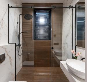 a bathroom with a shower and a toilet and a sink at Riviera Zoloche Resort & Spa in Vishenki +148 photos