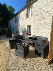 a group of chairs and tables in front of a building at les rives du Lay gîte Joly in Le Boupère