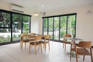 a dining room with a table and chairs and windows at Radateeree Boutique Resort in Chiang Mai