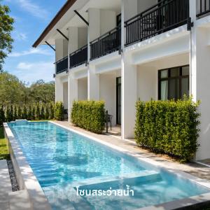 a swimming pool in front of a house at Radateeree Boutique Resort in Chiang Mai
