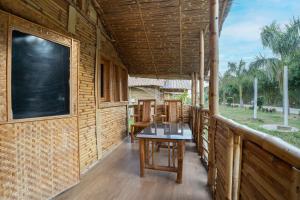 a porch of a wooden house with a table on it at Padmabati Park in Balasore