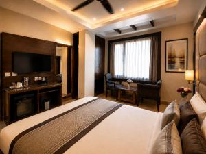 a hotel room with a large bed and a television at Hotel Atlanta Continental, Paharganj New Delhi in New Delhi +36 photos