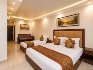 a hotel room with two beds and a desk at Hotel Atlanta Continental, Paharganj New Delhi in New Delhi