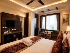 a hotel room with a bed and a television at Hotel Atlanta Continental, Paharganj New Delhi in New Delhi