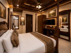 a bedroom with a large bed and a television at Hotel Atlanta Continental, Paharganj New Delhi in New Delhi