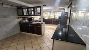 a kitchen with black counter tops and a large room at Ilemi Gardens in Nairobi +60 photos