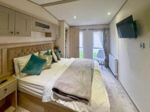 a bedroom with a large bed with green pillows at Abi Beaumont - Ty Mawr in Rowen