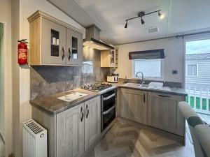a kitchen with wooden cabinets and a stove top oven at Abi Beaumont - Ty Mawr in Rowen