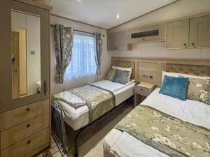 a small bedroom with two beds and a window at Abi Beaumont - Ty Mawr in Rowen +4 photos