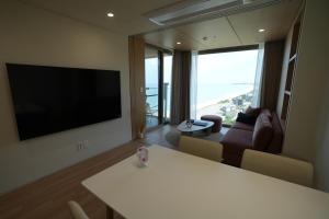 a living room with a flat screen tv and a couch at 클리프비치 in Sangun-ni