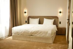 a bedroom with a large bed with white sheets and pillows at Monteva Boutique Hotel in Almaty