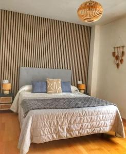 a bedroom with a bed and a striped wall at Ekhiola Txiki in Ochagavía