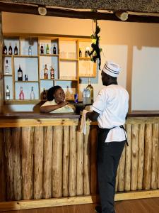 a man standing at a bar with a woman at Ewafe Safari Lodge-Murchison in Wanseko