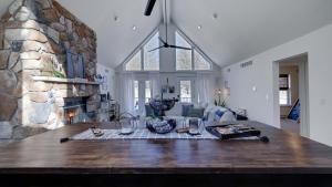 a living room with a stone fireplace and a table at Peak Pine by AvantStay in Albrightsville