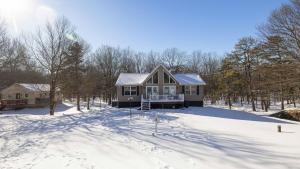 a house in the snow in the woods at Peak Pine by AvantStay in Albrightsville