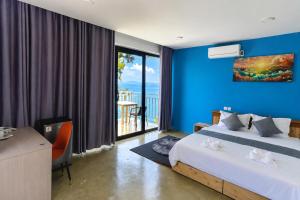a bedroom with blue walls and a bed and a balcony at The Cliff Bungalow in Koh Rong Sanloem +40 photos