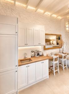 a kitchen with white cabinets and a sink and a table at TOP SUITES in Ermoupoli +28 photos