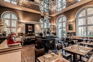 ein Restaurant mit Tischen, Stühlen und einem Kamin in der Unterkunft Sofitel Munich Bayerpost in München
