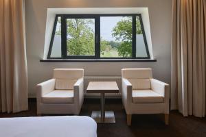 a room with two chairs and a table and a window at Van der Valk Hotel de Bilt-Utrecht in De Bilt +34 photos