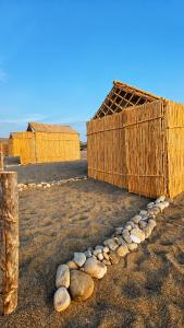 a row of rocks next to a wooden building at ESPACE AZAiMi in Tarîfa +1 photo