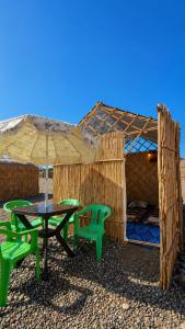 a picnic table and two chairs under an umbrella at ESPACE AZAiMi in Tarîfa