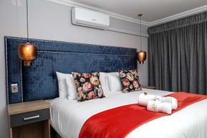 a bedroom with a large bed with a blue headboard at Lasaro Guest Lodge in Bethlehem