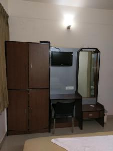 1 dormitorio con escritorio, espejo y tocador en Banyan Tree Comforts Mysore, en Mysore