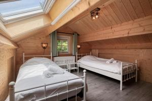 a bedroom with two beds in a wooden house at Luxe, rust en ruimte bij de Veluwse Vogels in Epe in Epe
