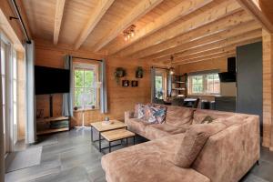 a living room with a couch and a table at Luxe, rust en ruimte bij de Veluwse Vogels in Epe in Epe