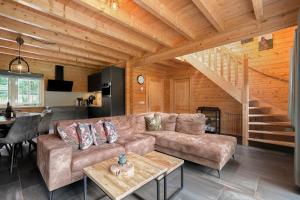 a living room with a couch and a table at Luxe, rust en ruimte bij de Veluwse Vogels in Epe in Epe