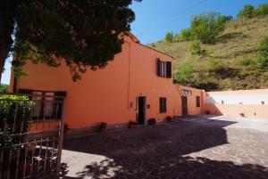 an orange building with a hill in the background at I due cipressi in Cagli +21 photos